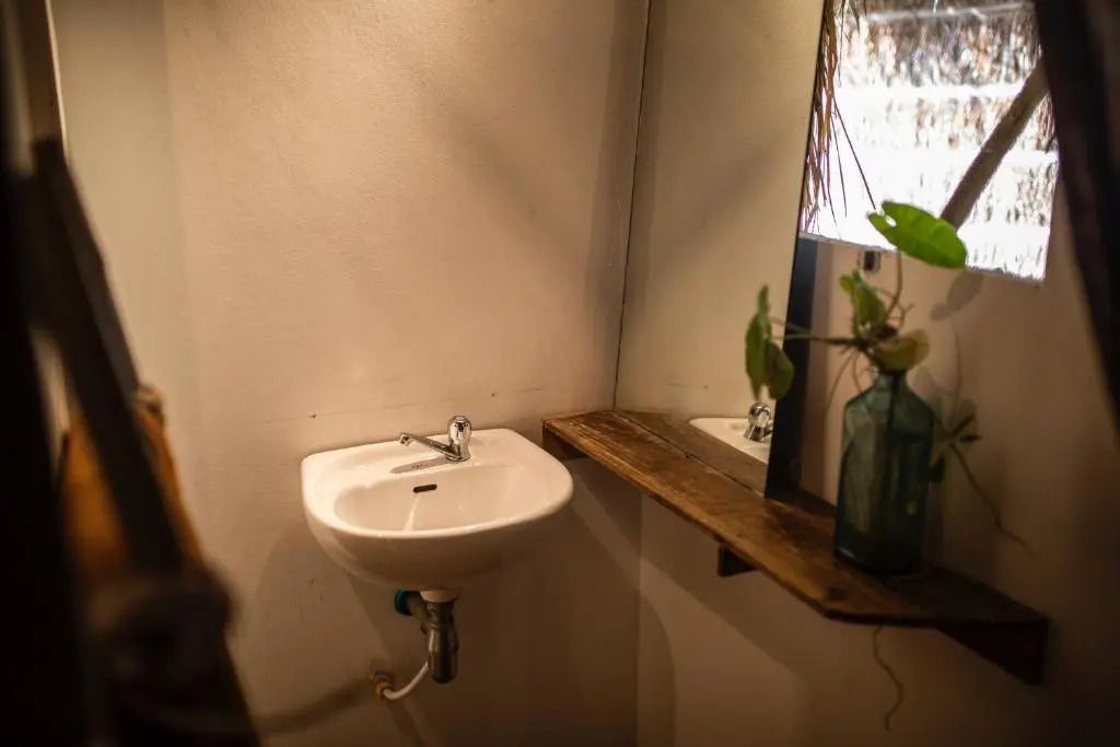 Waschbecken mit Holzablage in einem Bungalow-Bad