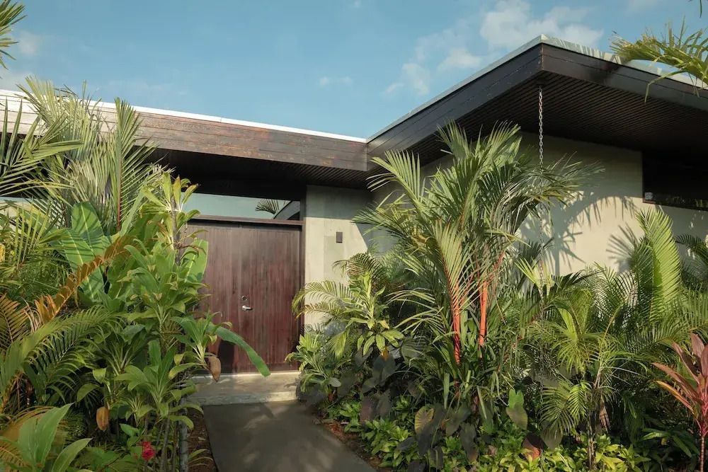 Eingang der Villa umgeben von üppiger tropischer Vegetation