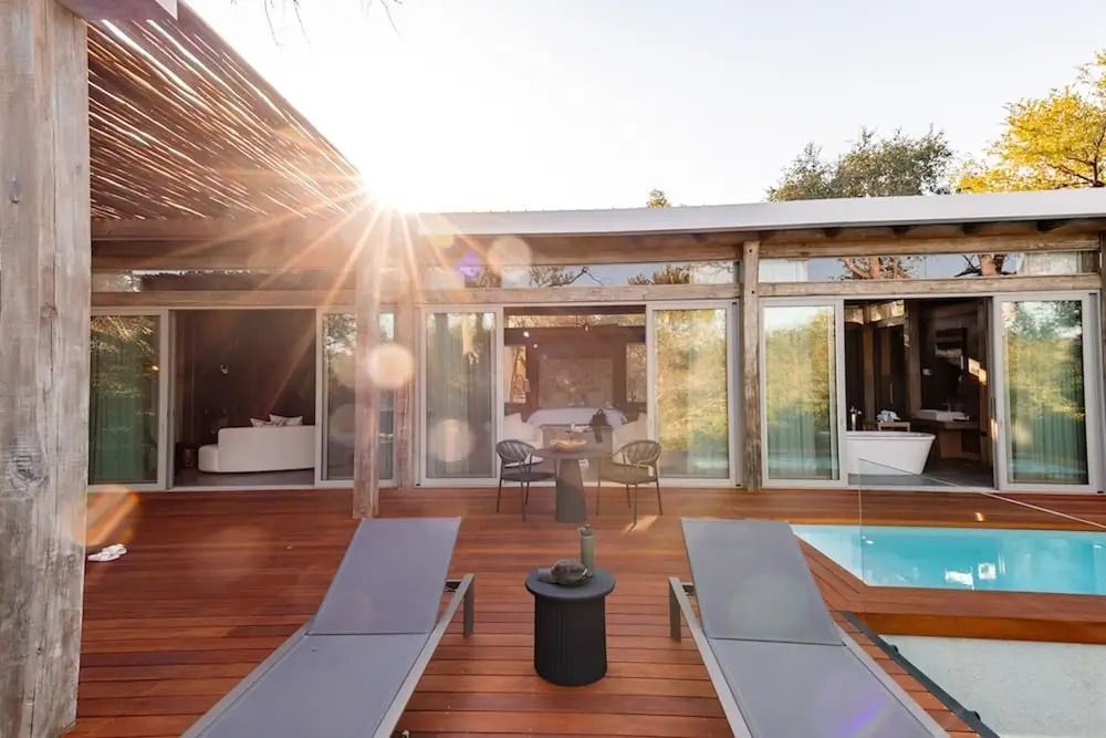 Moderne Terrasse mit Sonnenliegen und kleinem Pool bei Sonnenuntergang