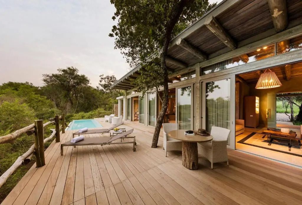 Terrasse einer Suite mit privatem Pool und Liegestühlen im grünen Umfeld