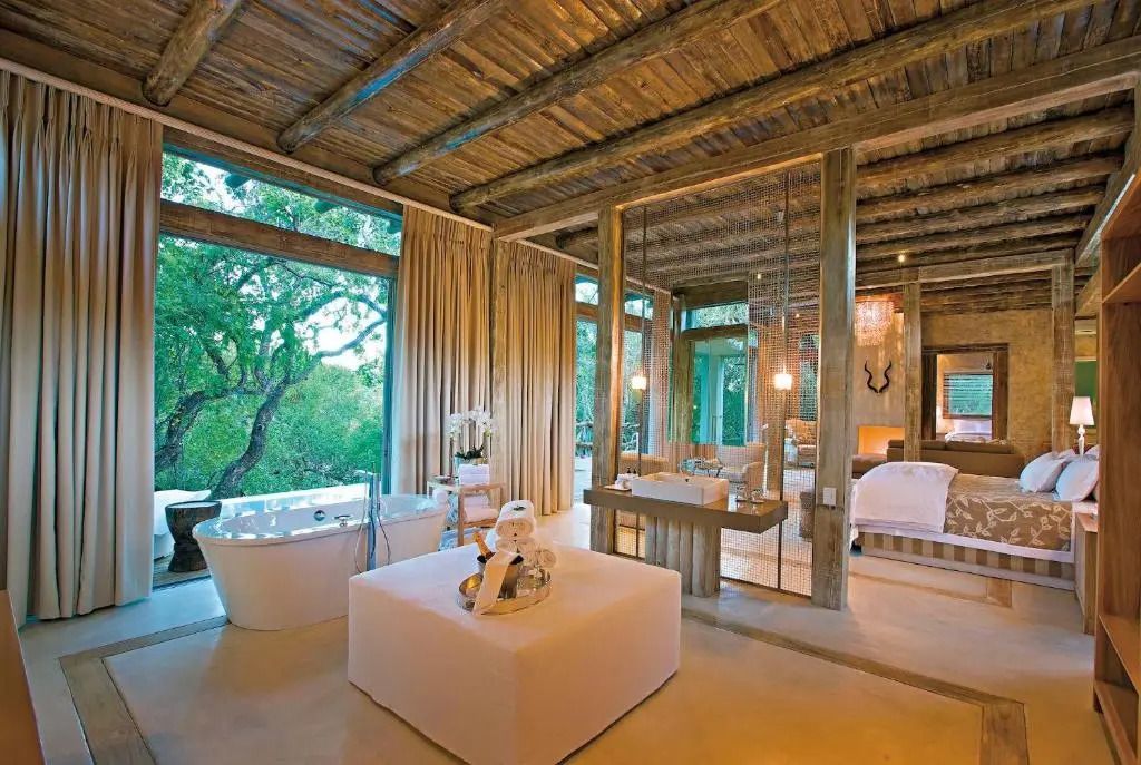 Innenansicht einer eleganten Suite mit freistehender Badewanne und Holzelementen