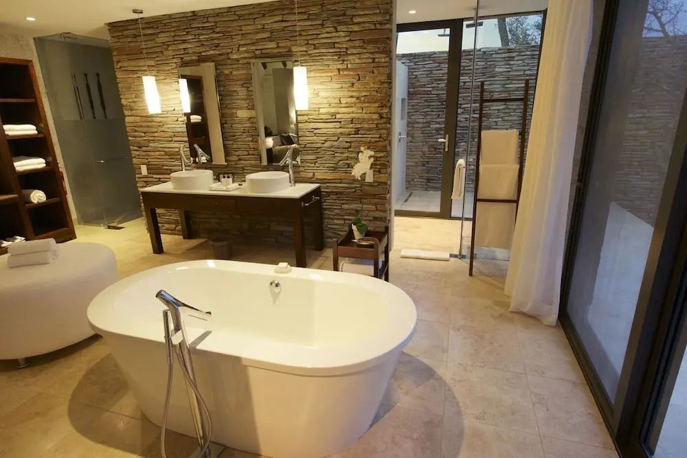 Modernes Badezimmer mit freistehender Badewanne und Steinakzenten