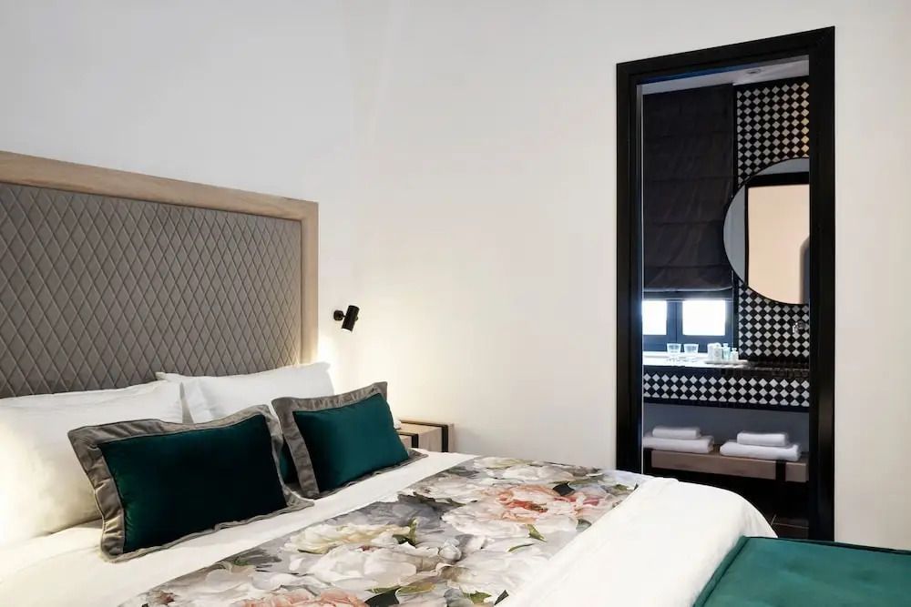 Helles Schlafzimmer einer Junior-Suite mit großem Bett und stilvoller Dekoration