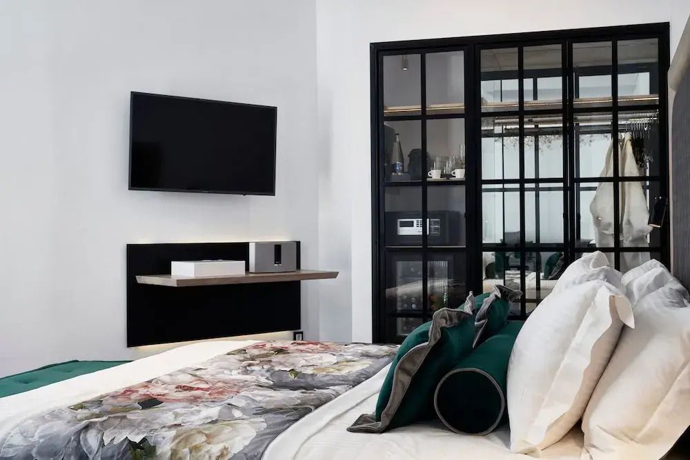 Schlafzimmer einer Junior-Suite mit modernen Annehmlichkeiten wie TV und Schrank