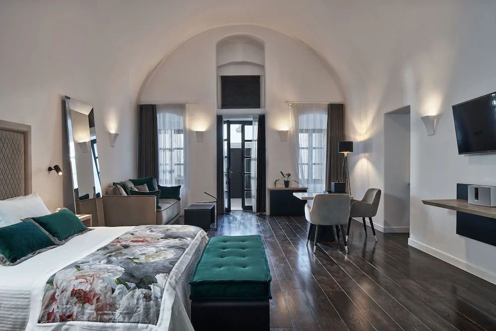Hotel-Suite mit hohen Decken, großen Fenstern und stilvoller Möblierung