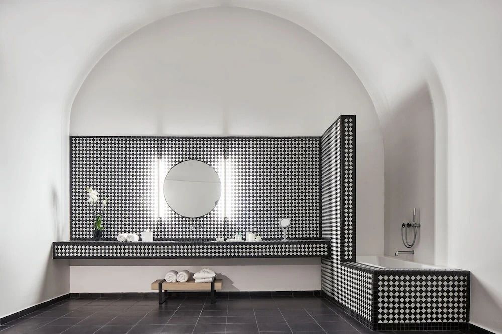 Modernes Badezimmer mit schwarz-weißen Fliesen und eleganter Einrichtung