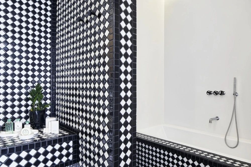 Modernes Badezimmer mit schwarz-weißen Kacheln und Badewanne