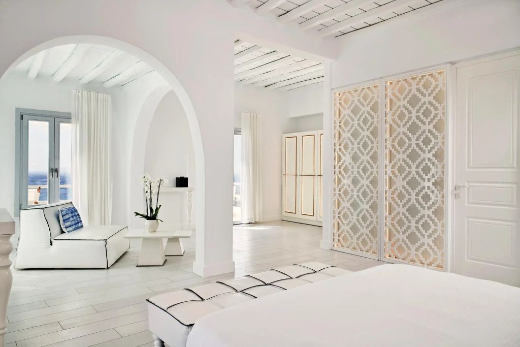 Geräumiges, weißes Zimmer mit eleganten Möbeln und subtilen Details