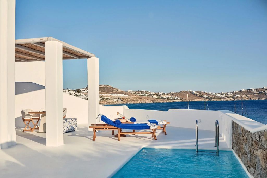 Privater Poolbereich mit Liegestühlen und Meerblick auf Mykonos