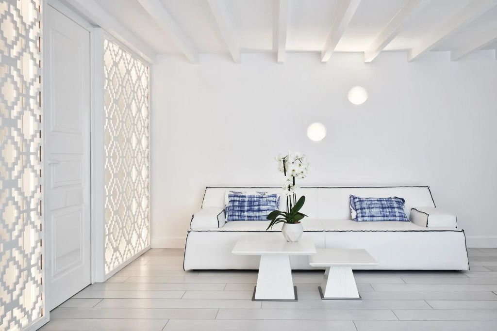 Lounge-Bereich mit dekorativer Wand und edlem Sofa.