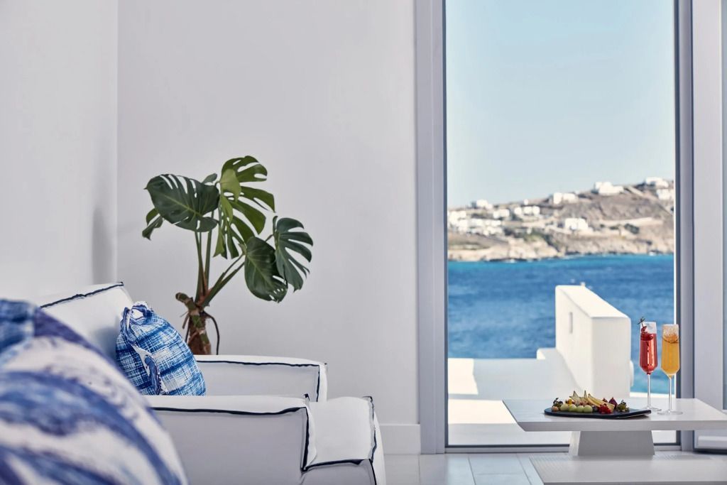 Heller Wohnbereich mit Blick auf das Meer durch ein großes Fenster