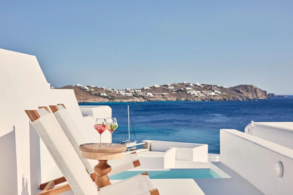 Terrasse mit Liegestühlen und Meerblick auf die Küste von Mykonos