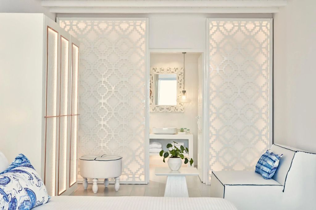 Blick auf das Schlafzimmer mit dekorativer Wand und Zugang zum Badezimmer. Pflanze zur Dekoration.