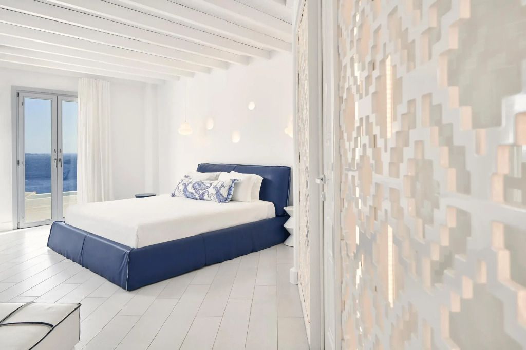 Elegante Junior-Suite mit blauem Doppelbett und stilvollen Details