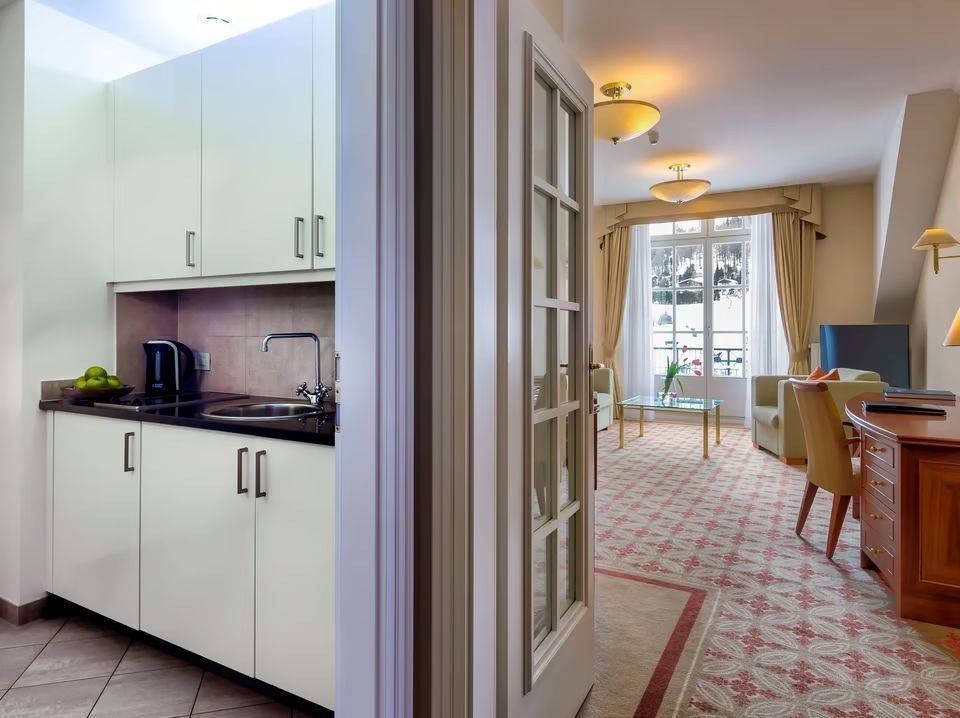 Ansicht von Küchenzeile und Wohnzimmer in der Deluxe Doppel Suite mit stilvollen Möbeln