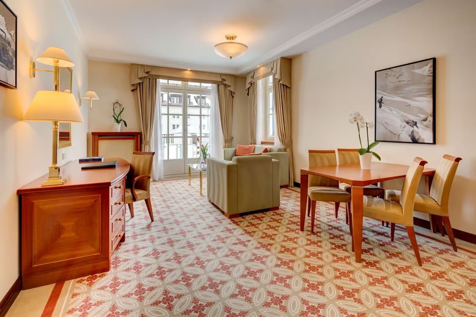 Großzügiger Wohnbereich mit Esstisch und eleganten Möbeln in der Grand Deluxe Suite
