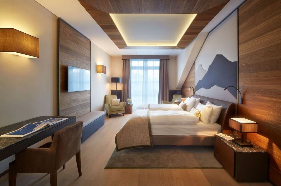 Helles Schlafzimmer in der Premier Alpine Suite mit großen Fenstern und moderner Dekoration