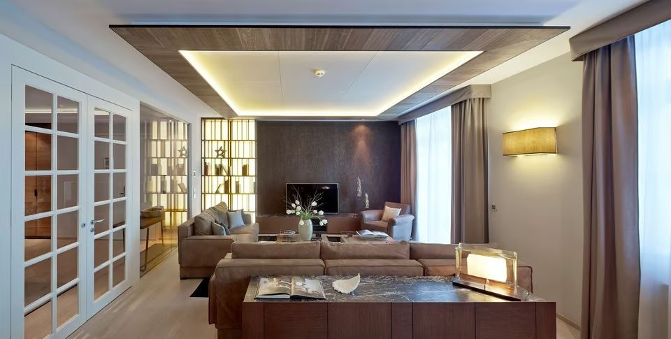 Moderner Wohnbereich der Suite mit stilvollem Sofa und Beleuchtung