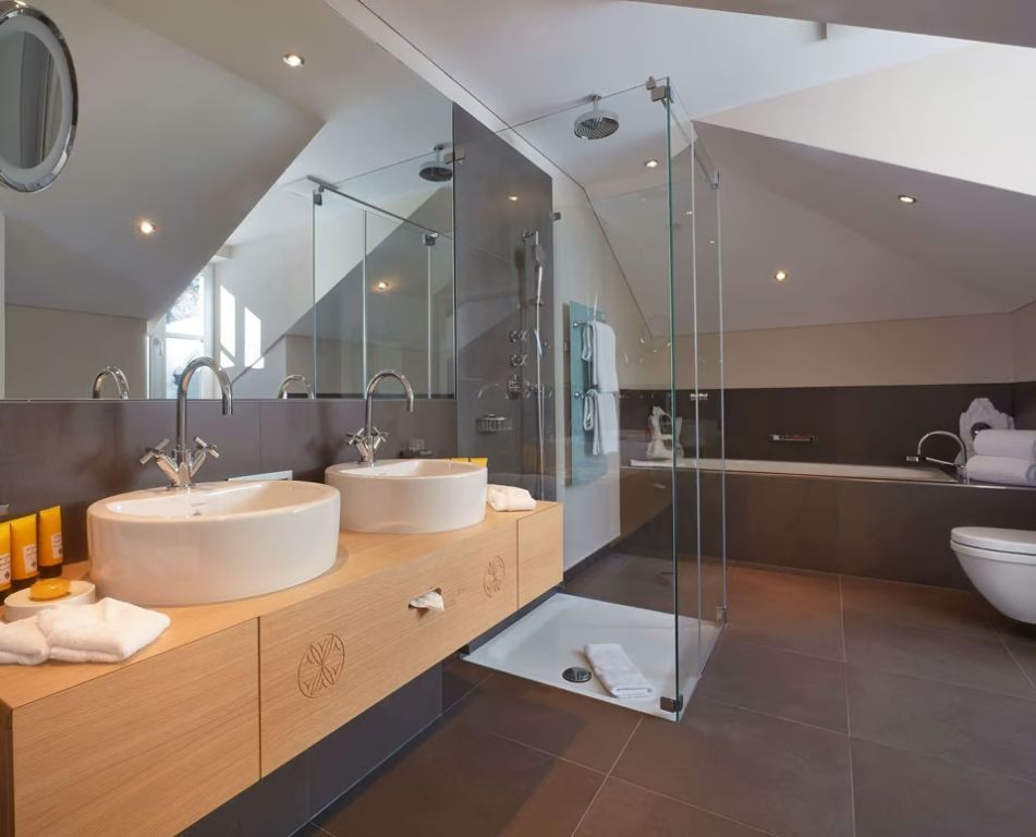 Geräumiges Badezimmer in der Suite mit Doppelwaschbecken und ebenerdiger Dusche