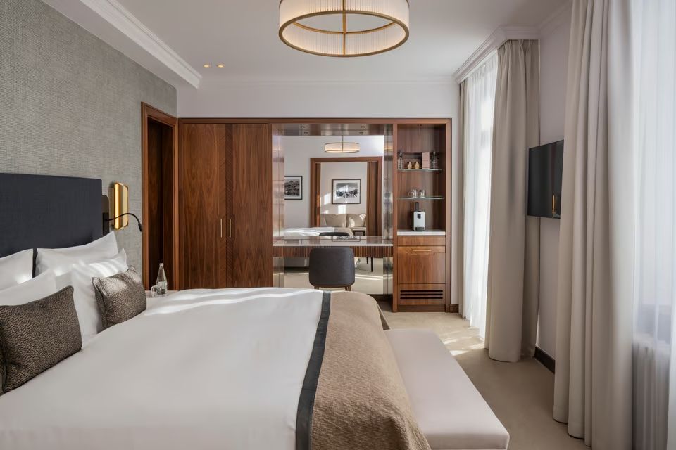 Luxuriöses Doppelbettzimmer mit modernen Holzmöbeln und großem Fenster.