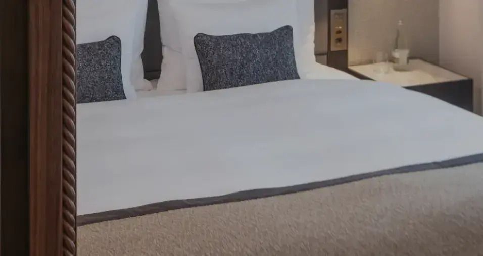 Detailansicht eines stilvollen Doppelbetts mit hochwertigen Kissen