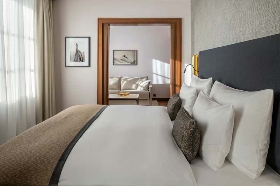 Elegante Junior-Suite mit Doppelbett und gemütlicher Sitzecke in neutralen Tönen