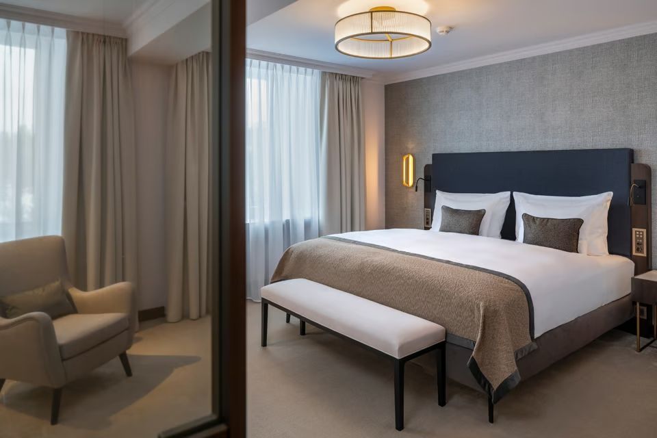 Elegantes Schlafzimmer mit Doppelbett und schlichten Dekor im Hotelzimmer