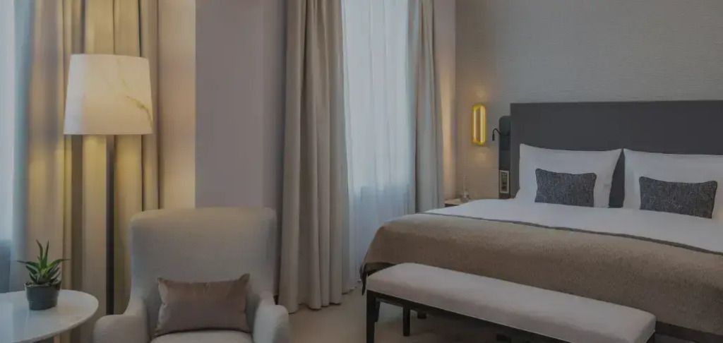 Elegantes Doppelzimmer mit bequemen Bett und großen Vorhängen.