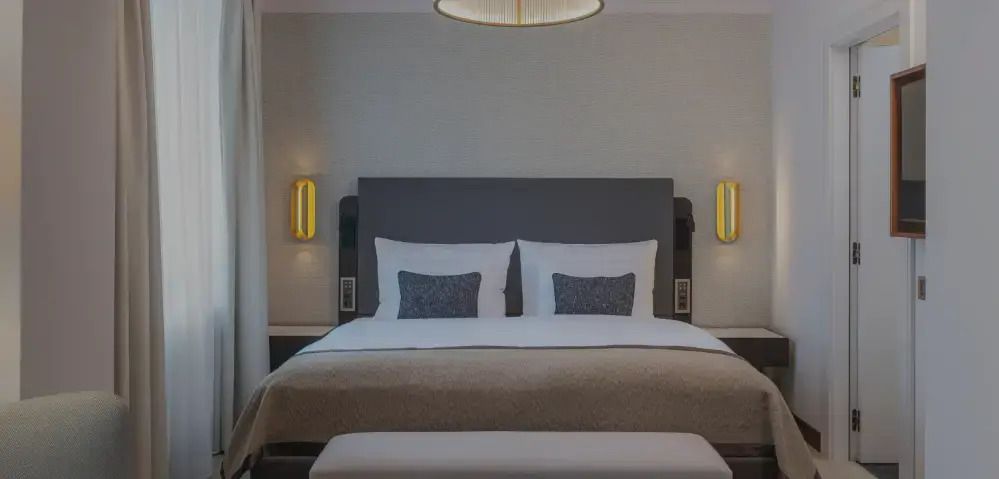 Modernes Doppelzimmer mit grauem Kopfteil und stilvollen Kissen.