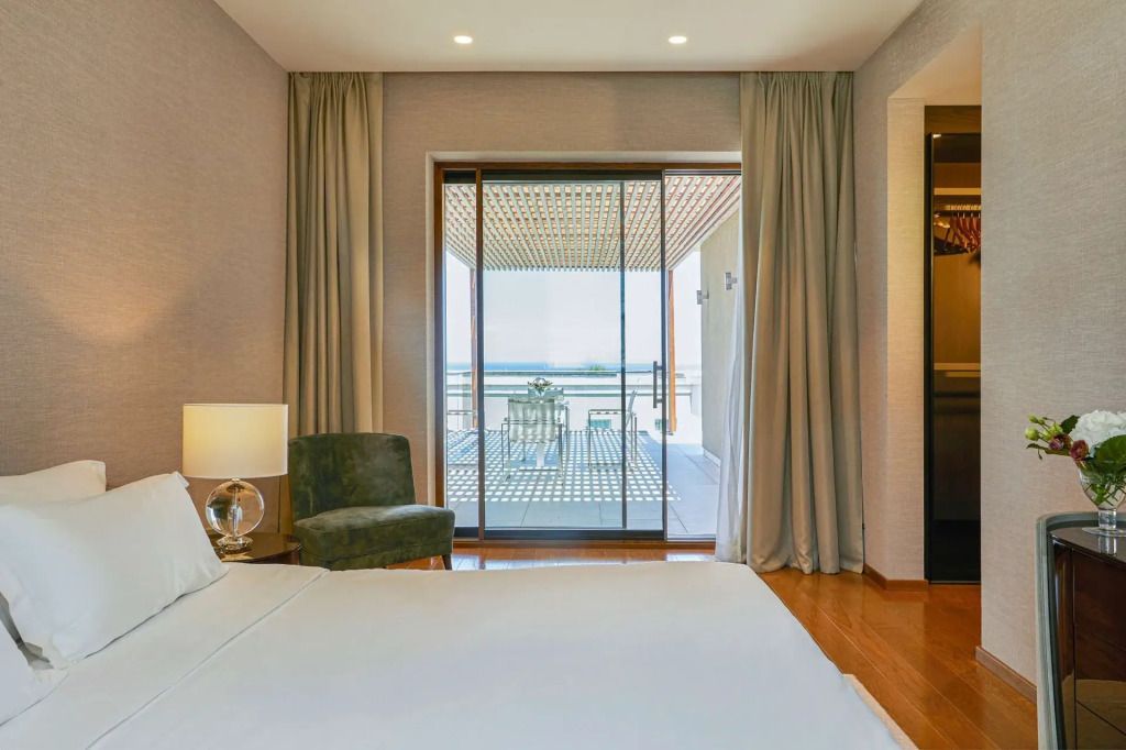Modernes Schlafzimmer mit Balkonzugang und Aussicht auf die Umgebung der Villa.