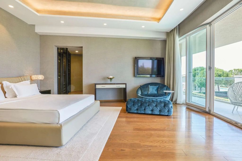 Luxuriöser Wohnbereich mit elegantem Sofa, Flachbildfernseher und Zugang zum Balkon.