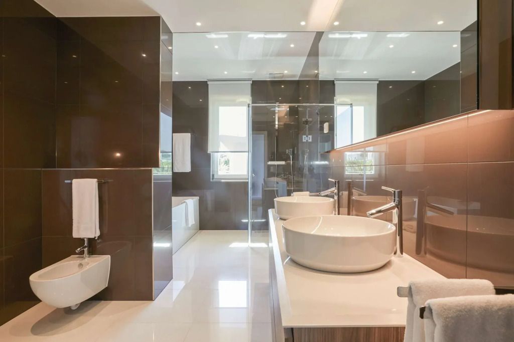 Modernes Badezimmer mit Doppelwaschbecken, Glasdusche und hochwertigen Armaturen.