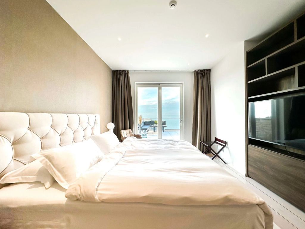 Modernes Schlafzimmer mit großem Fenster mit Meerblick