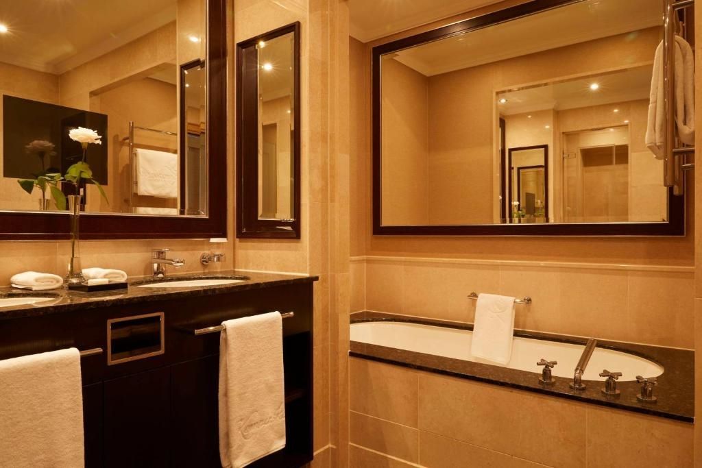 Modernes Badezimmer mit Badewanne und großen Spiegeln im Hotelzimmer