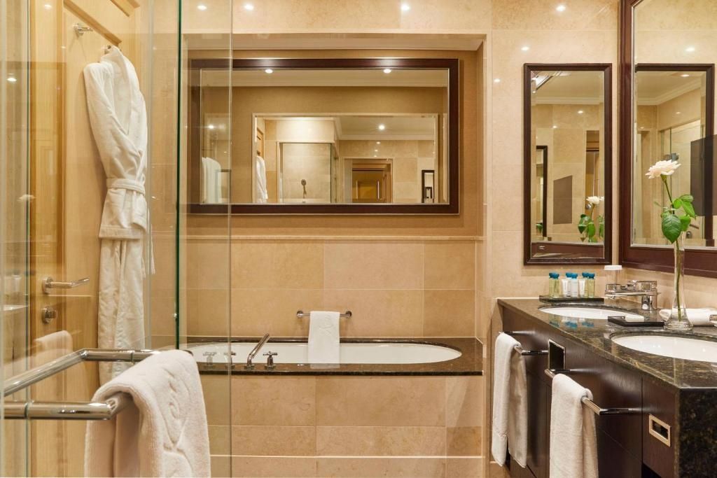 Modernes Badezimmer mit Badewanne und großer Spiegelwand