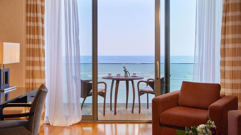 Balkon mit Tisch und Stühlen und Blick auf das Meer