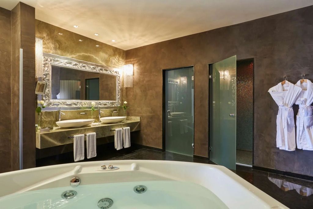 Elegantes Badezimmer mit Jacuzzi und modernen Waschbecken.