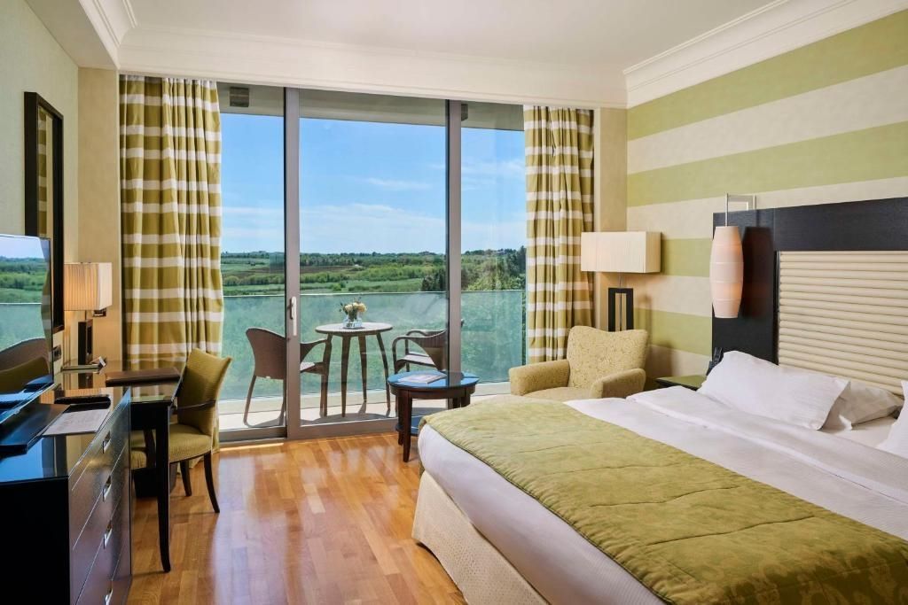 Zimmer mit Balkon und Blick auf den grünen Garten