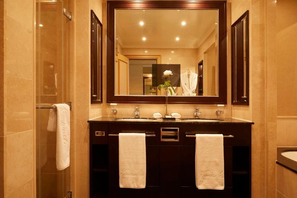 Luxuriöses Badezimmer mit Doppelwaschbecken und großer Spiegelwand im Kempinski Hotel
