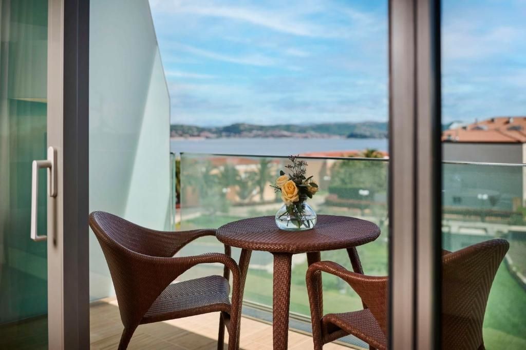 Balkontisch mit zwei Stühlen und Aussicht auf das Meer im Kempinski Hotel