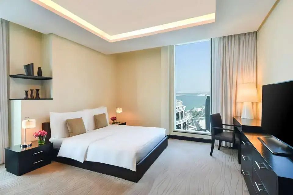 Elegantes Schlafzimmer mit modernen Möbeln und großem Fenster mit Meerblick