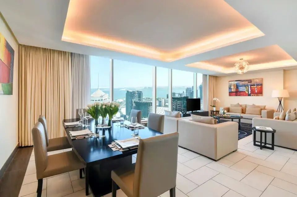 Helles Esszimmer in der Villa mit großem Tisch und Blick auf die Skyline.