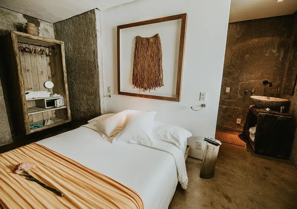 Gemütliches Bett mit natürlicher Wanddekoration in einer Luxussuite