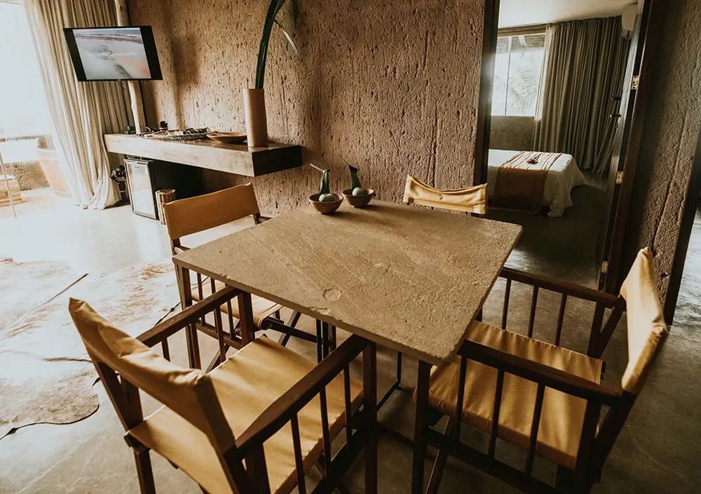 Einladender Essbereich aus Holz mit Blick auf ein elegantes Schlafzimmer