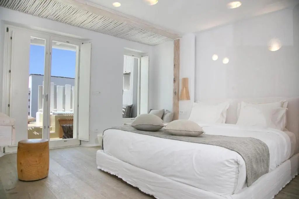 Helles Doppelzimmer mit großem Bett und Balkon im Kove Mykonos Hotel