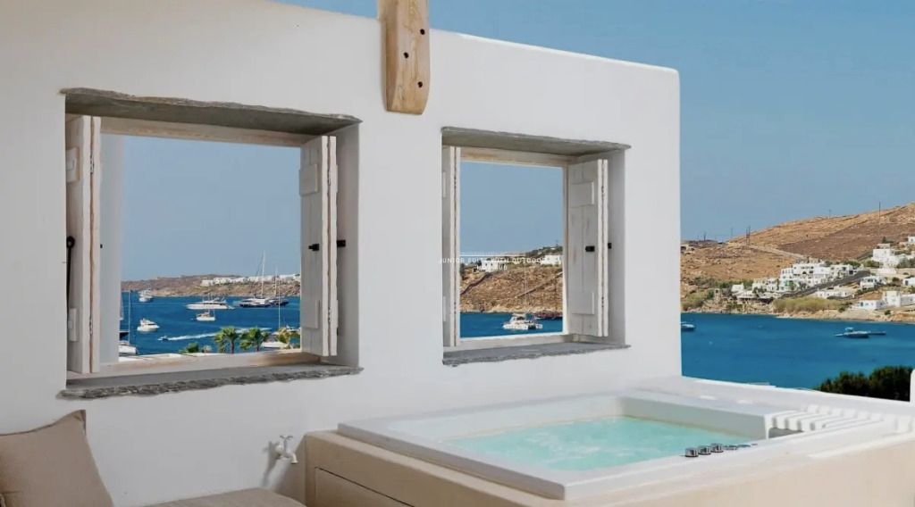 Whirlpool mit Blick auf das blaue Meer durch offene Fenster