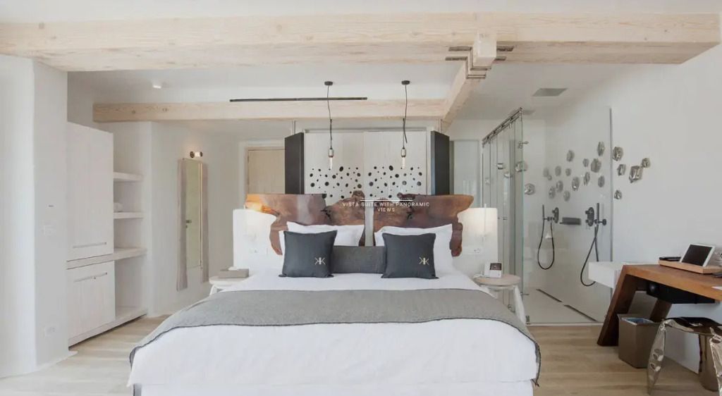 Moderne Suite mit Doppelbett und offener Regendusche.