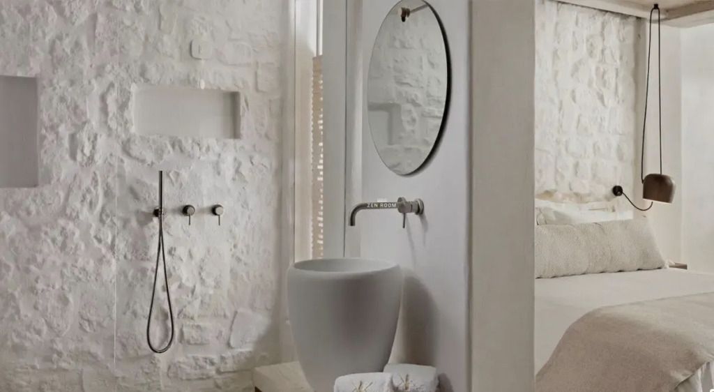 Modernes Bad mit Waschbecken aus Stein und runden Spiegel im Zen Doppelzimmer