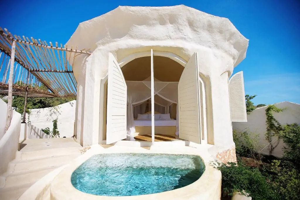 Runde Villa mit Privatpool und geöffneten Fensterläden unter blauem Himmel