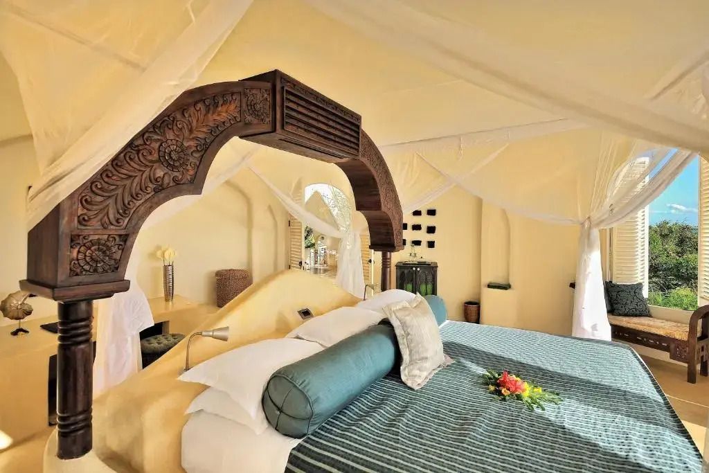 Detailansicht eines stilvollen Himmelbetts mit Holzschnitzereien in einer Villa